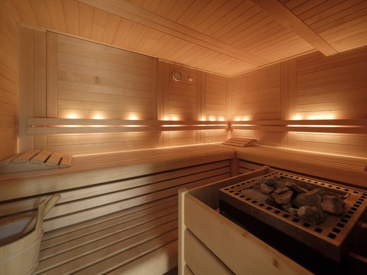 Ein Hotel mit Sauna am See? Ab in die Alte Wurzhütte! Helle hölzerne Sauna mit Steinofen und Beleuchtung