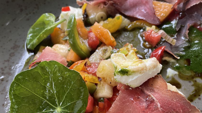 Schlemmen im Restaurant am Spitzingsee Bunte Vorspeise mit Schinken, Gemüse, Blattsalat und Käse auf grauem Teller