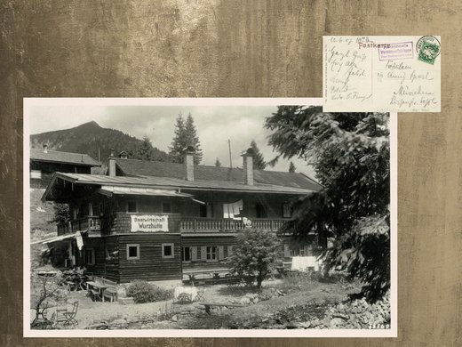 Euer authentischer Urlaub am Spitzingsee Schwarzweißfoto der Gastwirtschaft Wurzhütte mit Berg und Bäumen im Hintergrund