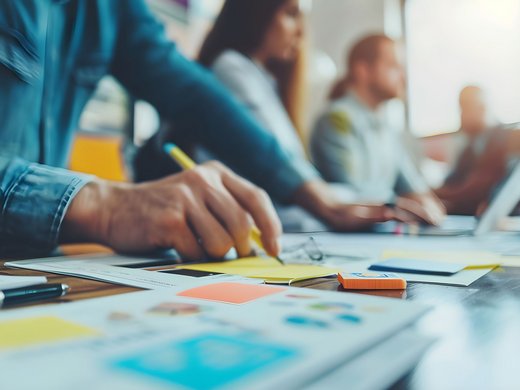 Willkommen im Tagungshotel in Oberbayern! Menschen bei einer Teamarbeit mit Schreiben und Laptop im Büro
