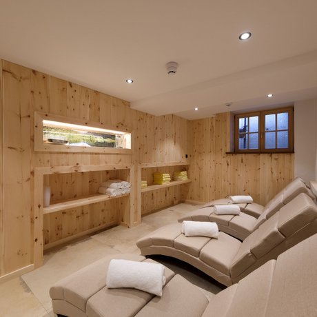 Ein Blick in die Alte Wurzhütte Entspannungsraum mit Liegestühlen und Holzwänden